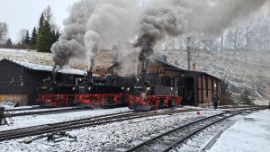 a steam train with black smoke coming out of it at Ferienwohnung zum Schlossblick in Wolkenstein +12 photos
