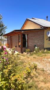 a small brick house with a window in a yard at Departamento Río Blanco in Cholila