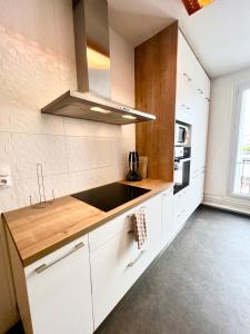 a kitchen with white cabinets and a sink at L'Ecume in Royan +21 photos