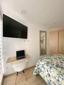 une chambre avec un lit et un bureau avec un ordinateur portable dans l'établissement Elegant Apartment in the Capitalia Building, à Manizales 14 autres photos