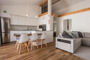 a kitchen and living room with a table and chairs at São Jorge Holiday Homes in Velas