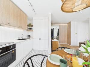 Una cocina y un comedor con mesa y sillas. en ApartamentySnu, Bema, en Radom