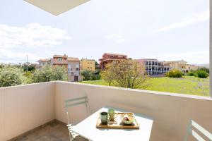 a balcony with a table and a view of a city at Chapelle Nove - Green Apartment in Elmas