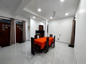 a dining room with an orange table and chairs at Y&Y villa in Narigama