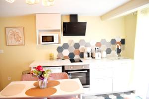 a kitchen with a table with a vase of flowers at La licorne poitevine in Poitiers
