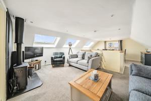 a living room with a couch and a tv at Coast View in Bideford