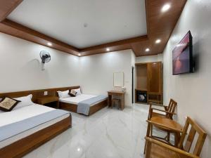 a hotel room with two beds and a tv at Thảo Vân hotel in Sầm Sơn