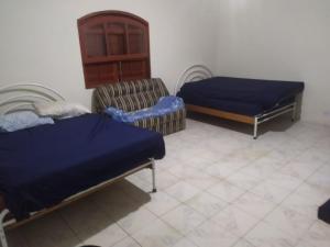 a room with two beds and a bed and a chair at Casa Praia com piscina Itanhaem in Itanhaém +78 photos