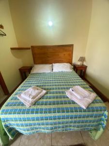 una camera da letto con un letto con due asciugamani sopra di Apartamentos Centricos Puerto Iguazu a Puerto Iguazú