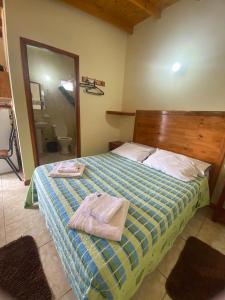 una camera da letto con un letto con due asciugamani sopra di Apartamentos Centricos Puerto Iguazu a Puerto Iguazú