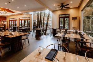 a restaurant with wooden tables and chairs and windows at The Funny Lion - Coron in Coron