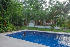 a woman in a swimming pool in a house at Tres Lodge- Private Pool - Nature and Comfort for Groups in Cocles