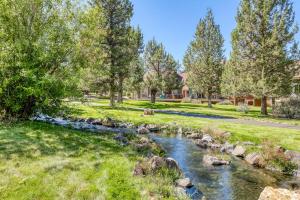 a stream in a park with trees and grass at Whispering Pines Haven in Redmond