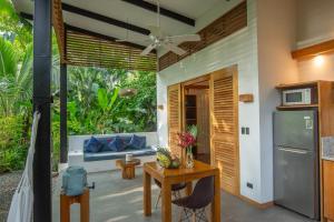 a kitchen and living room with a table and a refrigerator at Tres Lodge- Private Pool - Nature and Comfort for Groups in Cocles