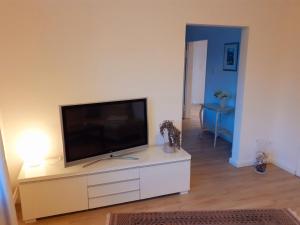 - un salon avec une télévision à écran plat dans un centre de divertissement blanc dans l'établissement Ferienwohnung Alte Post Retzen, à Bad Salzuflen