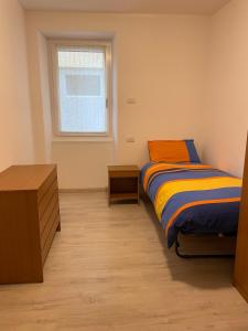 a bedroom with a bed and a dresser and a window at Casa Silvia in Morbegno