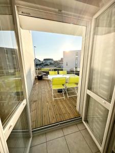 a balcony with a view of a table and chairs at T2 Hyper Cocon Terrasses - Parking in Larmor-Plage