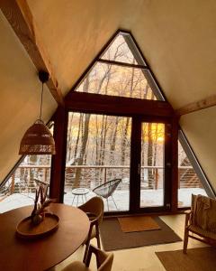 a room with a table and a large window at Juniper Chalet Mátra in Mátraszentimre