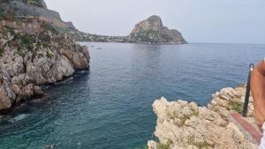 a person standing on a cliff looking at the water at Casa Don Paolo e Donna Caterina in Bagheria