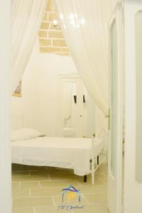 a white bedroom with a bed and a mirror at Mescia Alba x AP Apartment in Gallipoli