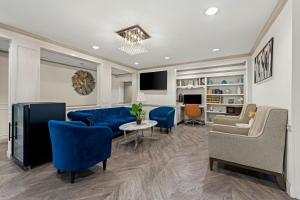 a living room with blue furniture and a tv at Quality Inn in Rocky Mount