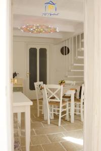 a white dining room with a table and chairs at Mescia Alba x AP Apartment in Gallipoli