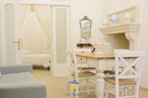 a white dining room with a table and chairs at Mescia Alba x AP Apartment in Gallipoli