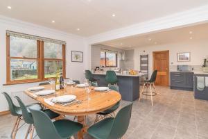 Una cocina y un comedor con mesa y sillas de madera. en Creigia-Betws, en Betws-y-coed