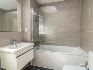 a bathroom with a white tub and a sink and a bath tubermott at Hallsands Beach House in Kingsbridge +31 photos