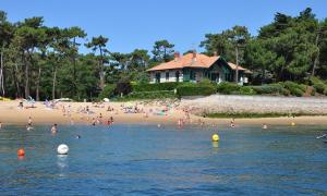 eine Gruppe von Menschen im Wasser an einem Strand in der Unterkunft Villa Naïade, Lège-Cap-Ferret, Arcachon Bay in Lège-Cap-Ferret