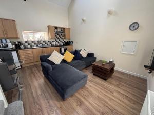 a living room with a couch and a kitchen at Coastal Bliss Charming Cottage near Borth beach in Borth +14 photos