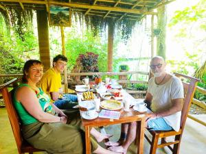 a group of people sitting around a wooden table at Jungle Face Inn in Ella