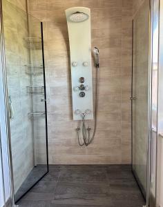 una ducha con puerta de cristal en un baño en Haus Strack, en Schwalmstadt 4 fotos más