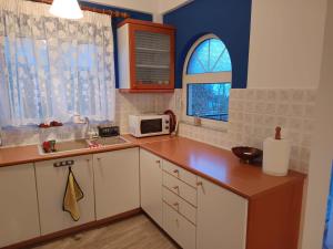 a kitchen with white cabinets and a sink and a window at Joel Apartment in Pefkali +10 photos