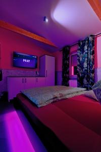 a bedroom with a bed with a tv on the wall at Lustra Stundenhotel - Adults Only in Landshut