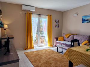 a living room with a couch and a window at Boka Bay Apartments in Herceg-Novi