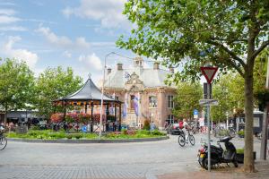 a moped parked in front of a building with a gazebo at Garden House Harry in Zandvoort