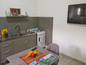 a kitchen with a table and a sink and a stove at Departamento Olivia in Ushuaia