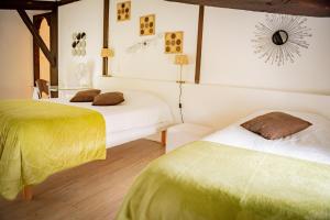 a bedroom with two beds with green and white sheets at Hôtel Henri IV - Restaurant in Eauze