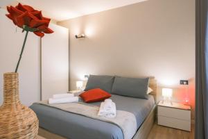 a bedroom with a bed with a vase with a flower at Costa blu - terrace overlooking the lake & pool in Riva di Solto