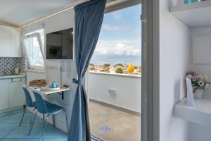a kitchen with a table and a view of the ocean at Beauty Home Sorrento in Sorrento