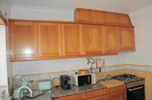 Una cocina con gabinetes de madera y microondas. en Casa da Costa de Lavos, en Figueira da Foz 19 fotos más