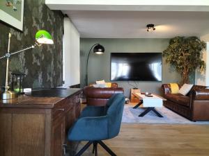 a living room with a couch and a tv at La seigneurie de Godefroy in Bouillon
