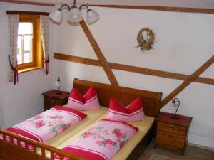 ein Schlafzimmer mit zwei Betten und rosa Kissen in der Unterkunft Pension Bernhardt in Schwarzenberg/Erzgebirge