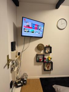 un salon avec une télévision à écran plat sur un mur dans l'établissement Logements jacuzzi silencieux, à Deuil-la-Barre