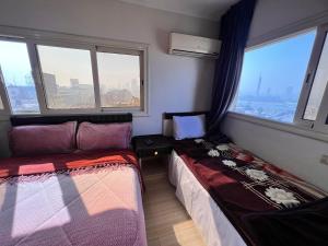ein Zimmer mit zwei Betten und zwei Fenstern in der Unterkunft Isis Hostel 2 in Kairo