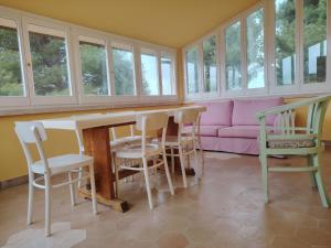 フォリーニョにあるcasaRegina b&b in collinaのリビングルーム(テーブル、椅子、ピンクのソファ付)