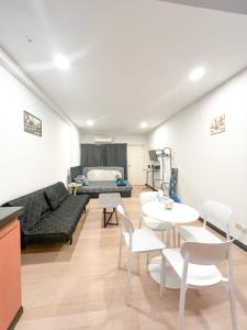 a living room with a couch and a table and chairs at KK City Api Api Block 1 Above Mcd Studio Homestay 2-3 pax in Kota Kinabalu