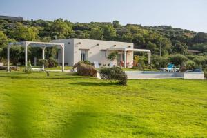 カステルサルドにあるVilla Fior d Acqua - Castelsardoの緑の芝生とスイミングプールのある家