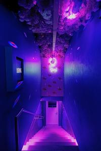 a purple hallway with a staircase with purple lights at Lustra Stundenhotel - Adults Only in Landshut
